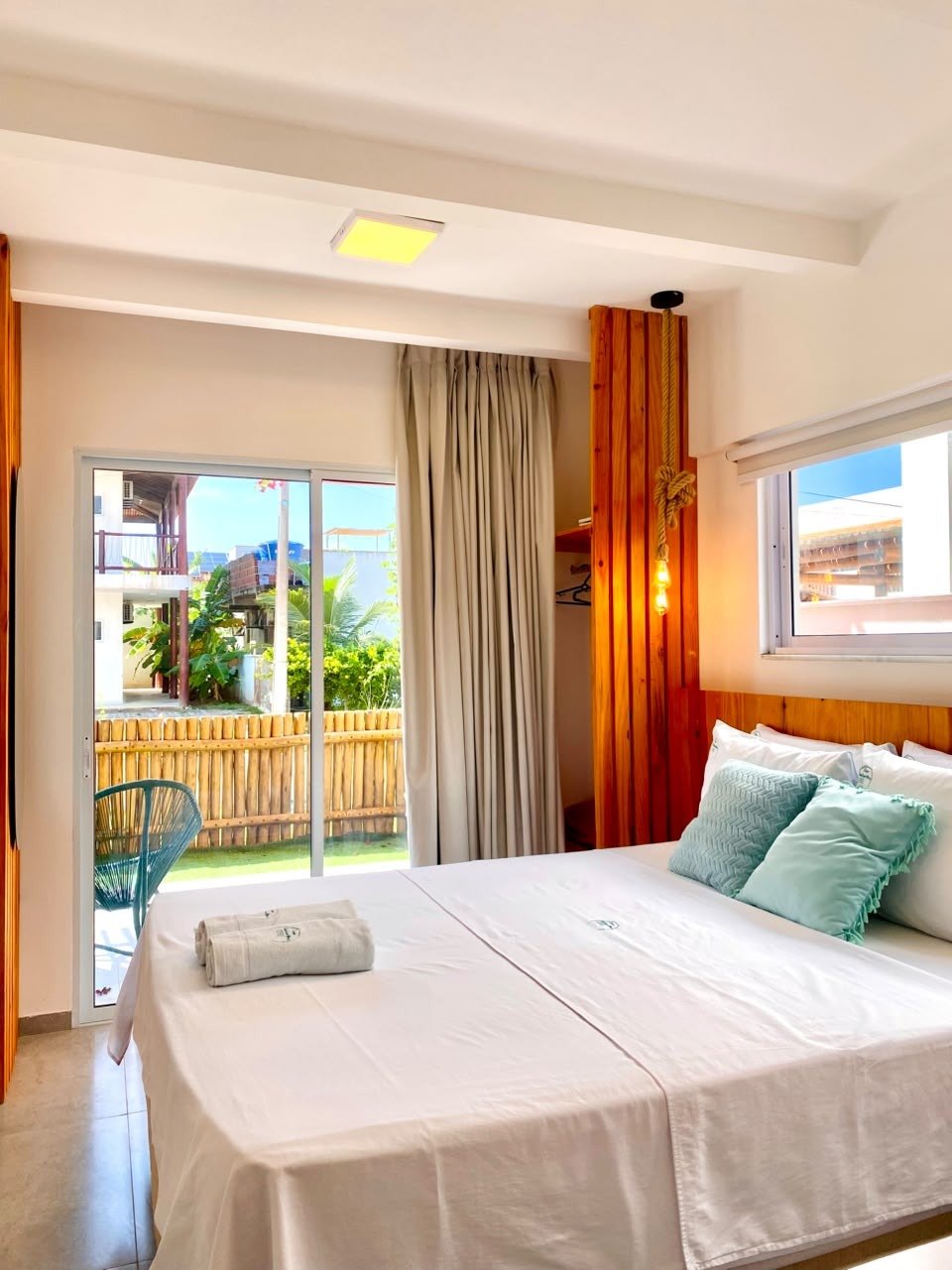 Quarto do chalé com cama de casal e porta para o jardim