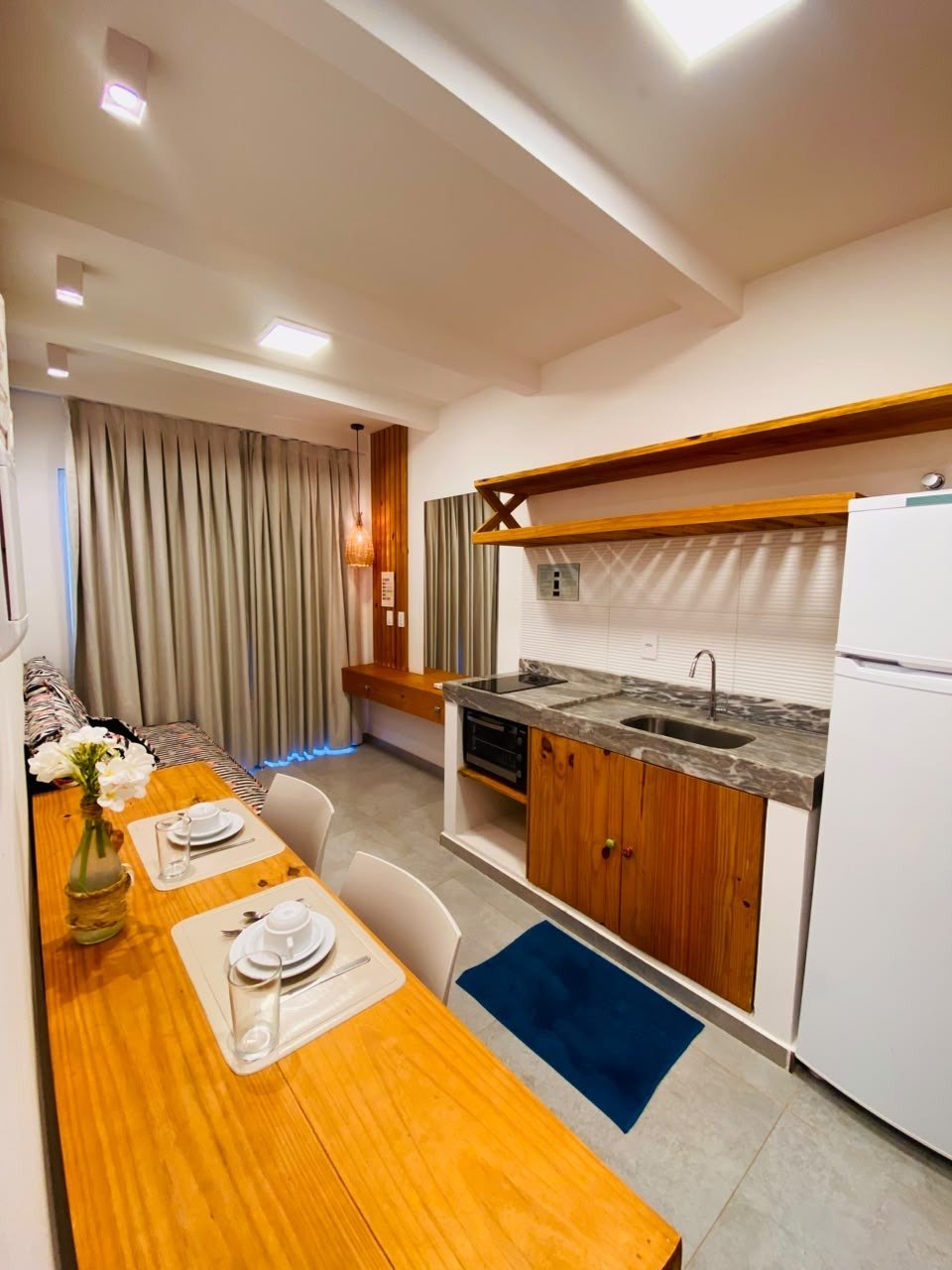Cozinha do chalé com geladeira, fogão e mesa de refeições